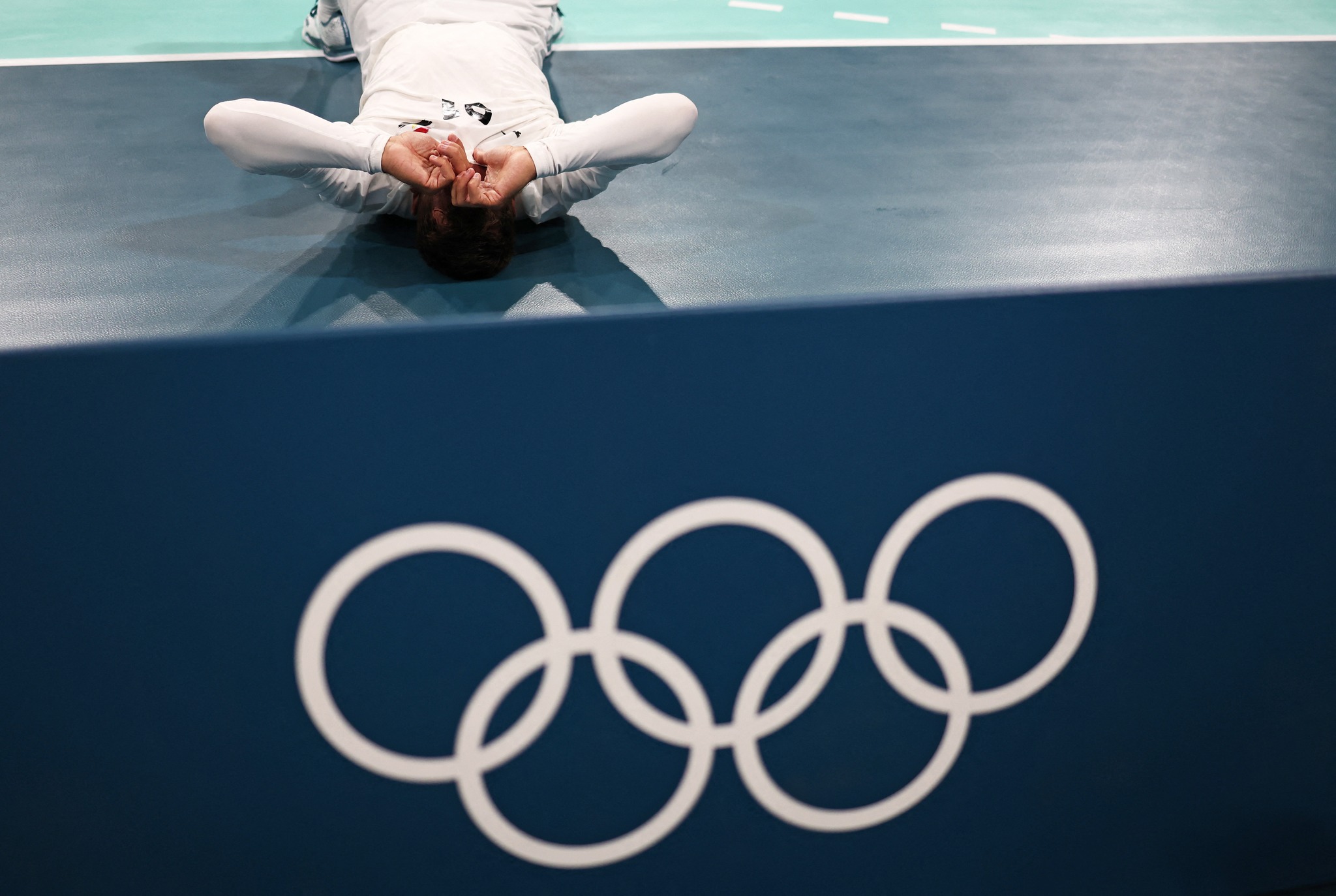 Paris 2024 Olympics - Handball - Men's Quarterfinal - Spain vs Egypt - Lille, Pierre Mauroy Stadium, Villeneve-d'Ascq, France - August 07, 2024. Mohammad Sanad of Egypt reacts while lying on the floor of the court after losing the match REUTERS/Eloisa Lopez